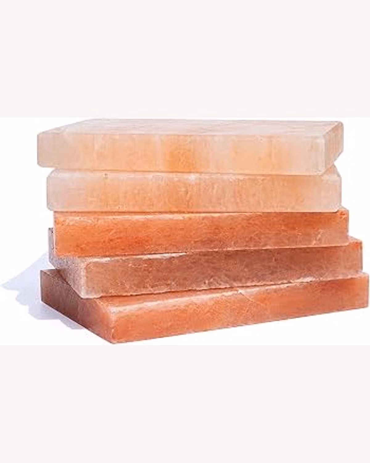 Several pink salt cooking plates stacked for a larger order
