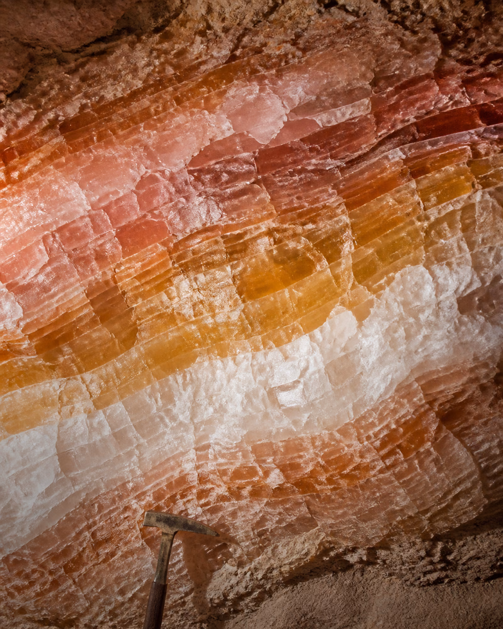 Geological salt seam with diagonal pink, amber, and white bands